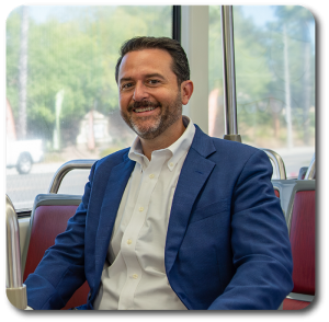 Picture of Colin Parent sitting on a bus. Picture from Colin's website for Assembly.