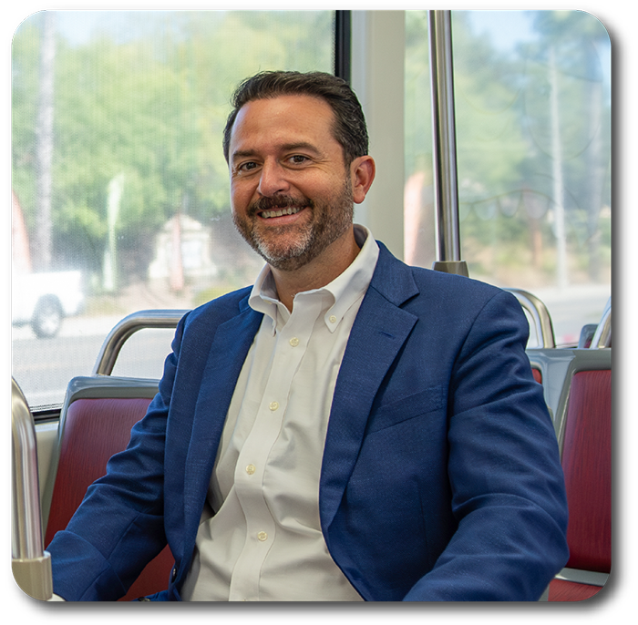Picture of Colin Parent sitting on a bus. Picture from Colin's website for Assembly.