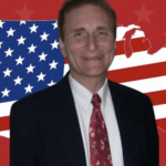 Picture of George Van Hasselt smiling in a business suit and tie against a graphic of the continental USA as a USA flag against a red background with red stars