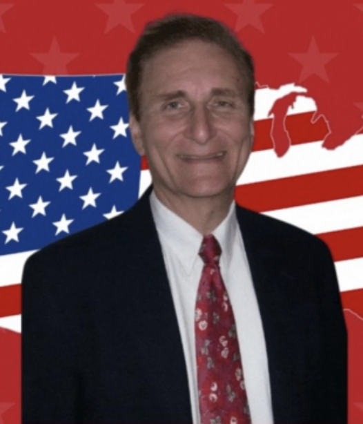 Picture of George Van Hasselt smiling in a business suit and tie against a graphic of the continental USA as a USA flag against a red background with red stars