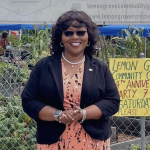 Picture of Racquel Vasquez smiling in front of a community garden celebration in Lemon Grove