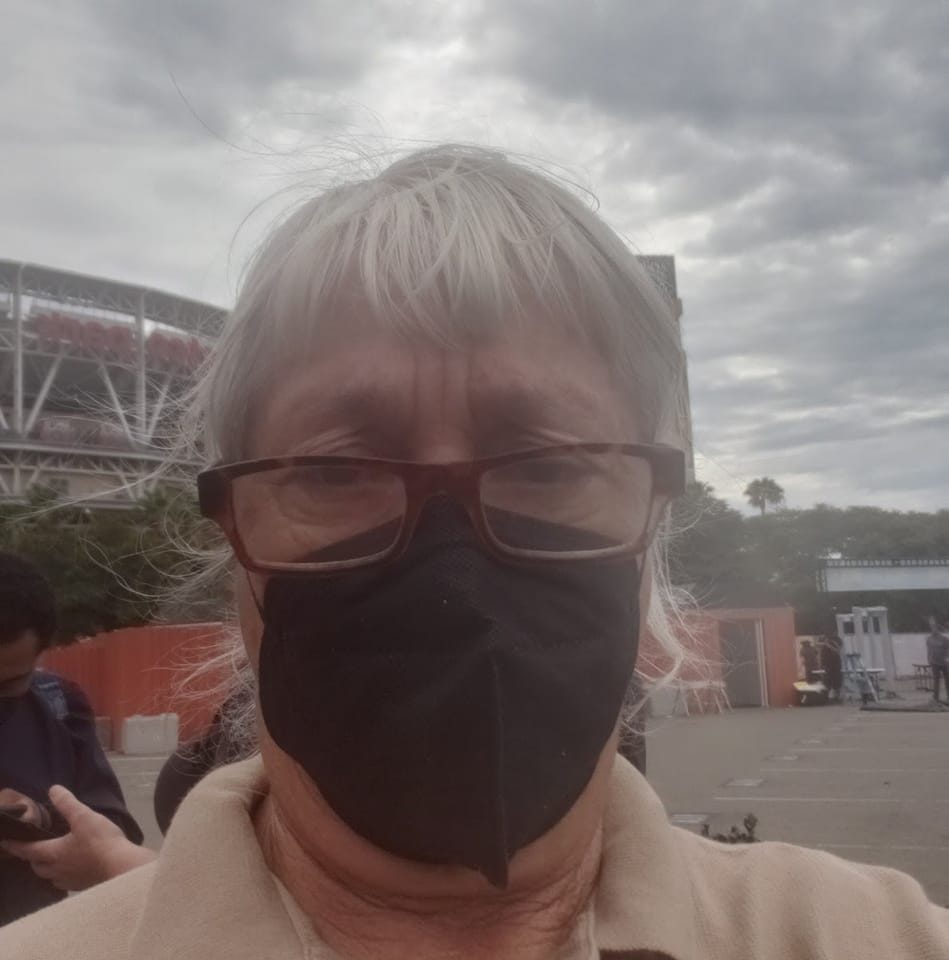 Headshot of Miriam Kanter Plotkin in a black face mask and glasses outside a stadium